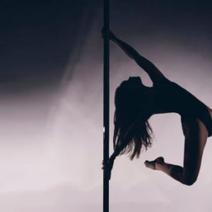 Frau Pole Trick auf Pole Dance Stange im Pole Dance Studio Wien