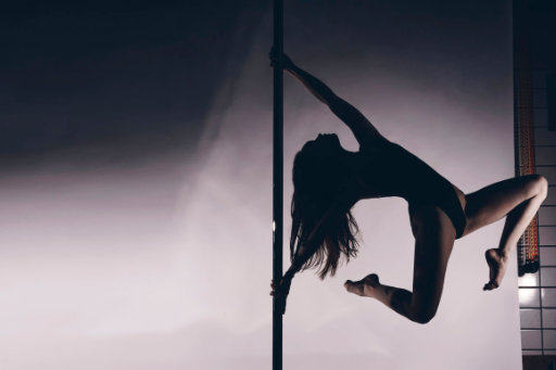 Frau Pole Trick auf Pole Dance Stange im Pole Dance Studio Wien