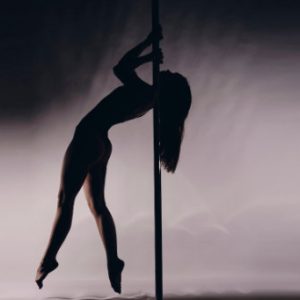 Frau Pole macht Shoulder Mount auf Pole Dance Stange