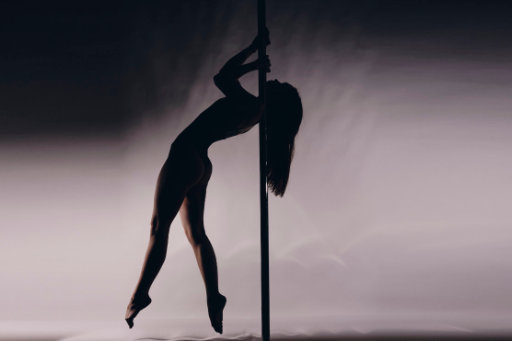 Frau Pole macht Shoulder Mount auf Pole Dance Stange