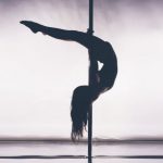 Frau Pole Trick, kopfüber auf Pole Dance Stange