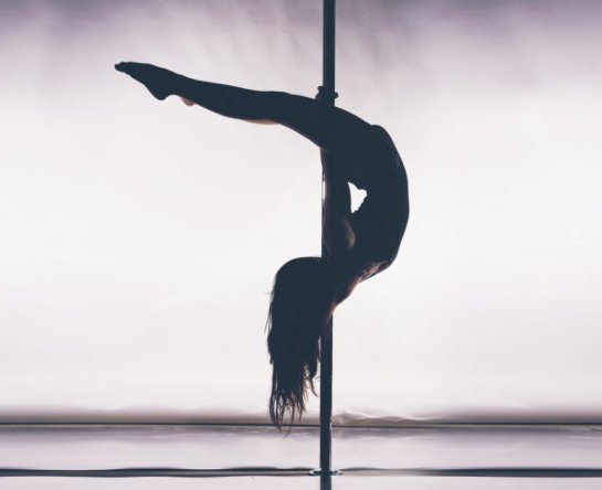 Frau Pole Trick, kopfüber auf Pole Dance Stange