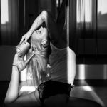 Frau tanzend am Boden vor der Pole Stange