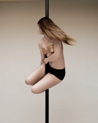 Frau Pole Trick auf Pole Dance Stange im Pole Dance Studio Wien